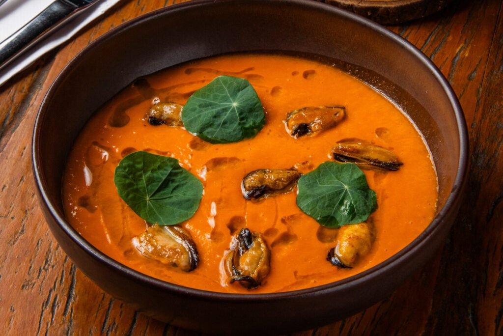 A Sopa de tomate confit com mexilhões na brasa e capuchinha é um dos novos pratos do Jabalí | Foto: Vitor K. Neves