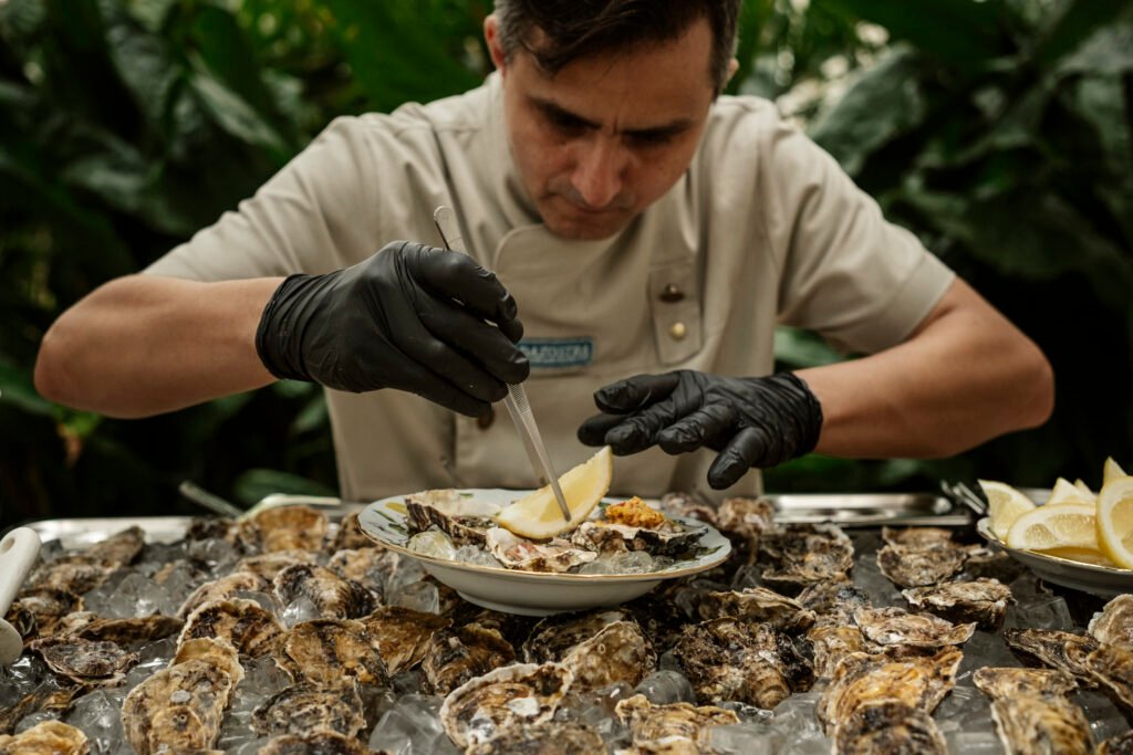 O chef Pedro Franco prepara ostras frescas no Leila | Foto: Gui Galembeck